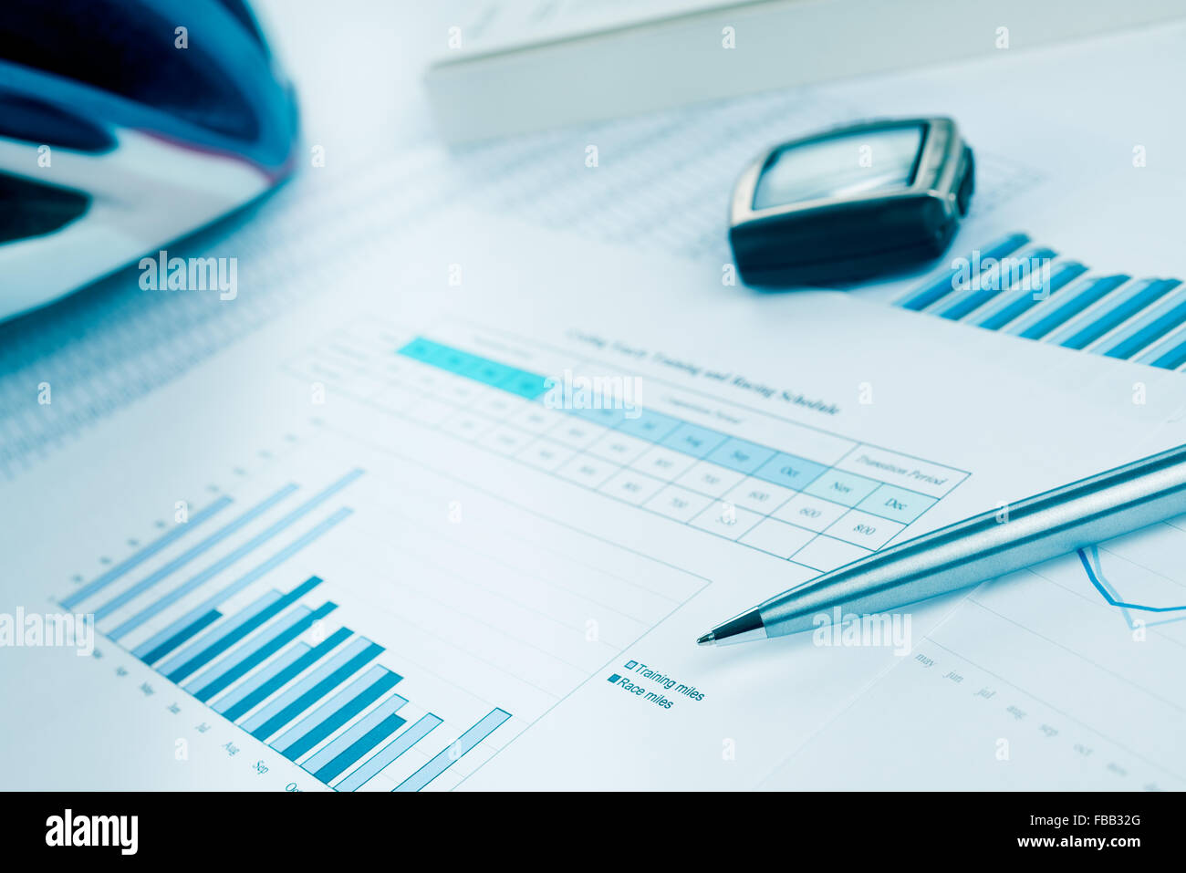 La formation et le plan de course pour le vélo ou le triathlon avec un stylo, un casque et un moniteur de fréquence cardiaque. Dans les tons bleu. Banque D'Images