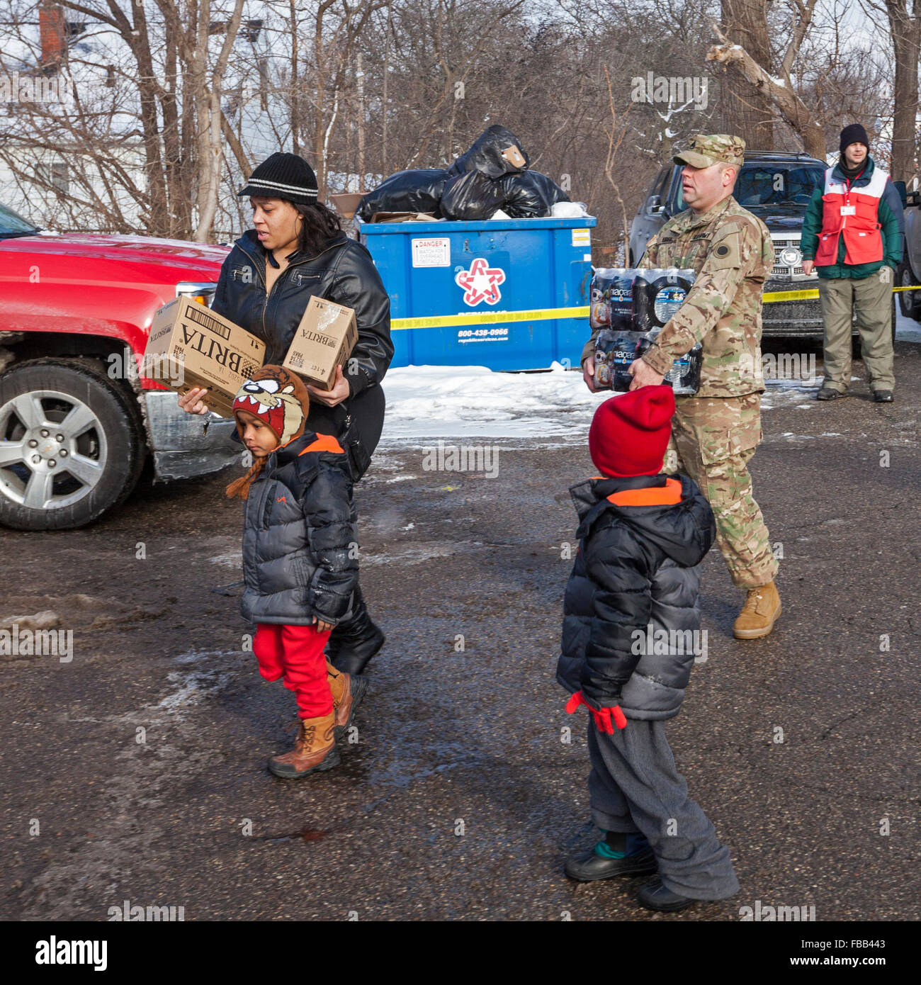 Flint, Michigan USA - 13 janvier 2016 - Les résidants pick up de l'eau en bouteille et des filtres à eau à partir de la Croix Rouge, les bénévoles de secours en cas de catastrophe et les membres de la Garde nationale à la Caserne # 6. L'eau et des filtres ont été distribués après la réduction des coûts par des fonctionnaires de l'état conduit à des niveaux élevés de plomb dans l'alimentation en eau de la ville. Crédit : Jim West/Alamy Live News Banque D'Images