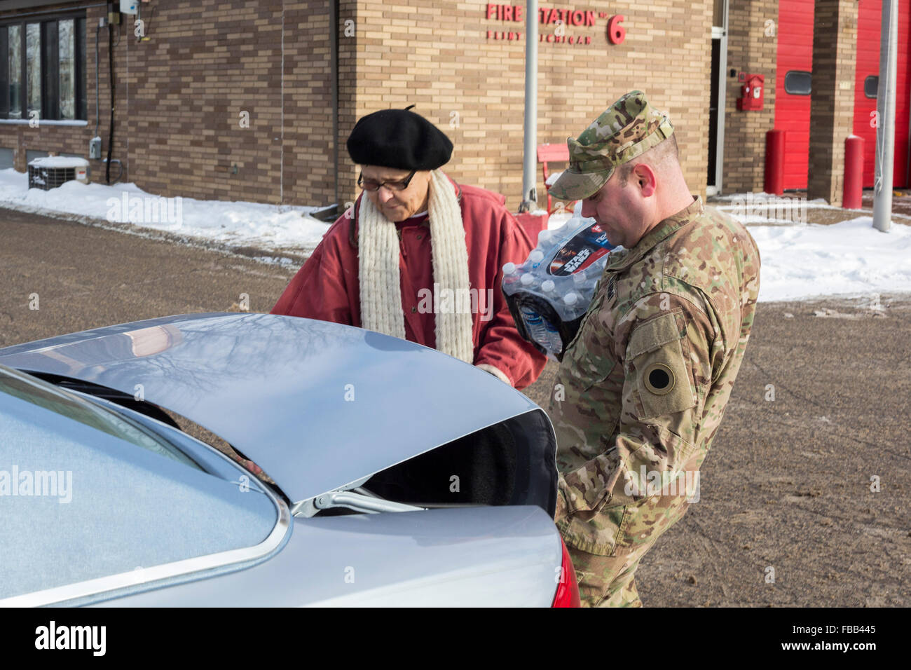Flint, Michigan USA - 13 janvier 2016 - Les résidants pick up de l'eau en bouteille et des filtres à eau à partir de la Croix Rouge, les bénévoles de secours en cas de catastrophe et les membres de la Garde nationale à la Caserne # 6. L'eau et des filtres ont été distribués après la réduction des coûts par des fonctionnaires de l'état conduit à des niveaux élevés de plomb dans l'alimentation en eau de la ville. Crédit : Jim West/Alamy Live News Banque D'Images