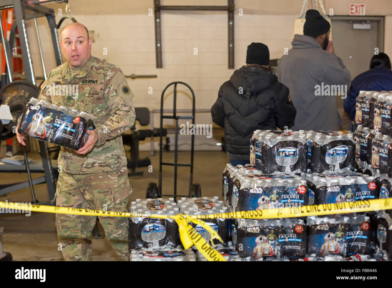 Flint, Michigan USA - 13 janvier 2016 - Les résidants pick up de l'eau en bouteille et des filtres à eau à partir de la Croix Rouge, les bénévoles de secours en cas de catastrophe et les membres de la Garde nationale à la Caserne # 6. L'eau et des filtres ont été distribués après la réduction des coûts par des fonctionnaires de l'état conduit à des niveaux élevés de plomb dans l'alimentation en eau de la ville. Crédit : Jim West/Alamy Live News Banque D'Images
