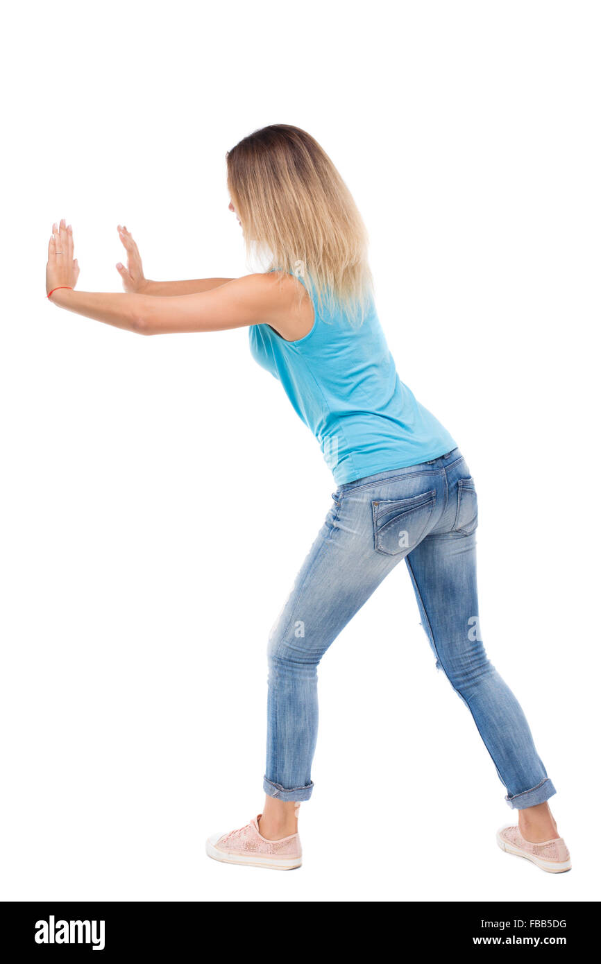 Vue arrière de la femme pousse mur. Plus isolé sur fond blanc. Vue arrière Vue arrière. collection les gens de personne. blonde en jeans et chemise bleu pousse quelque chose sur mes propres. Banque D'Images