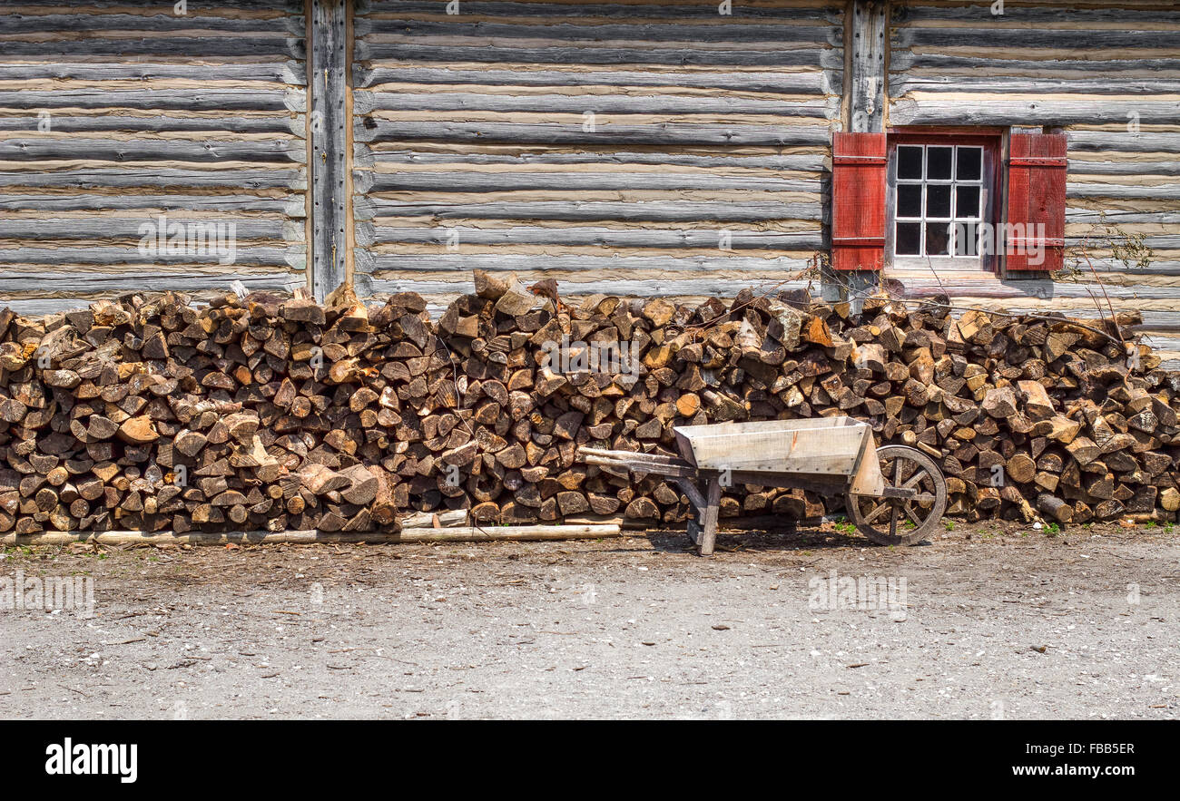 Cabane rustique avec des piles de bois de chauffage et vintage brouette. fort michimilimackinac state park. Mackinaw City (Michigan). Banque D'Images