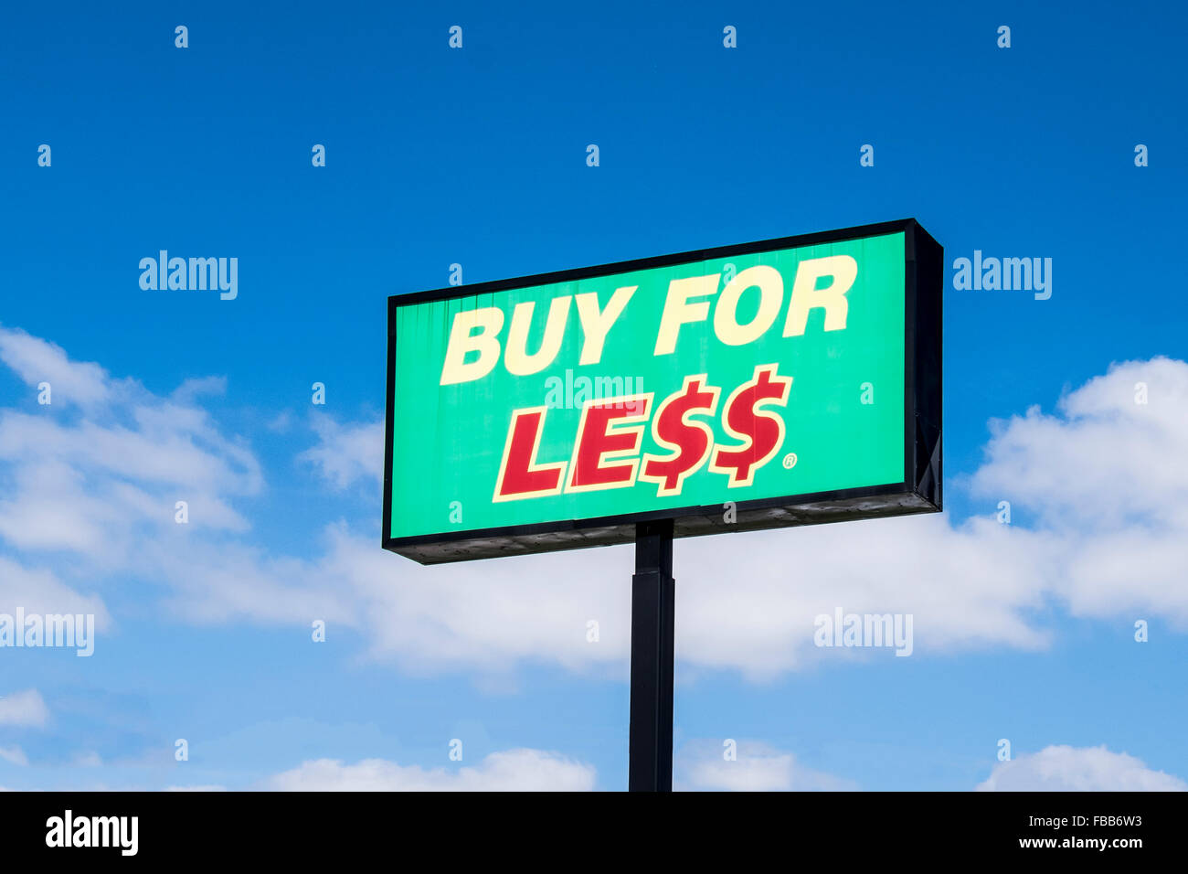 Acheter pour moins d'un pole sign against a blue sky, publicité un magasin d'alimentation à Oklahoma City, Oklahoma, USA. Banque D'Images