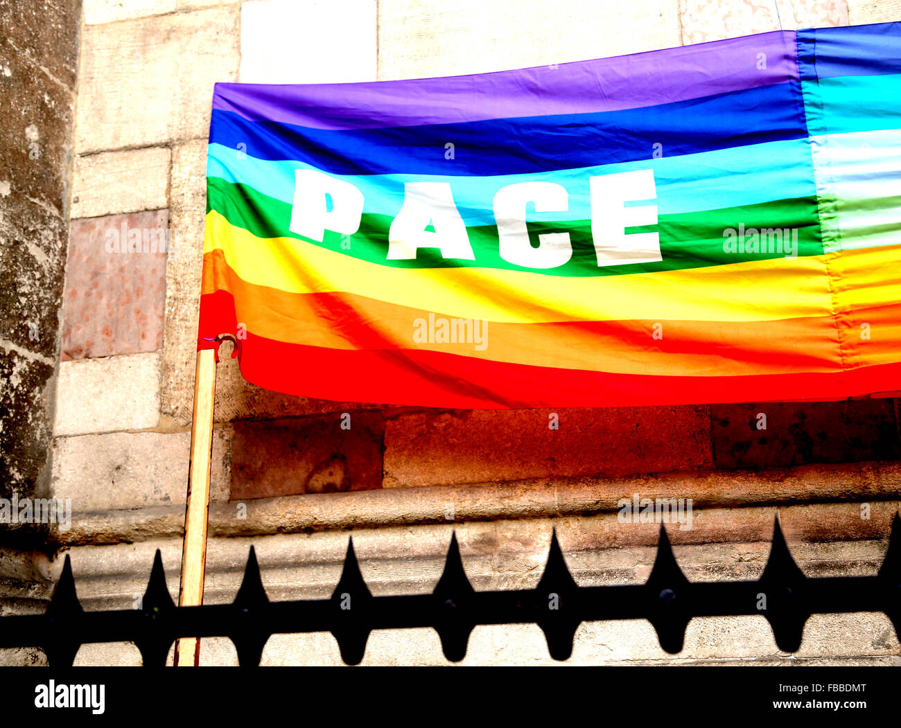 Arc-en-ciel multicolore drapeau de paix au cours d'une manifestation de pacifistes italiens dans une ville italienne derrière grates Banque D'Images