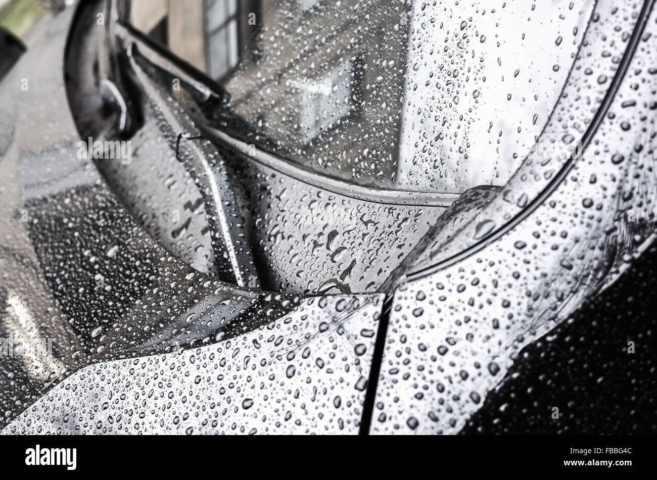 Capot de voiture brillante métallique noir fragment et essuie-glaces avec gouttes de pluie sur elle, photo gros plan avec focus sélectif et shal Banque D'Images