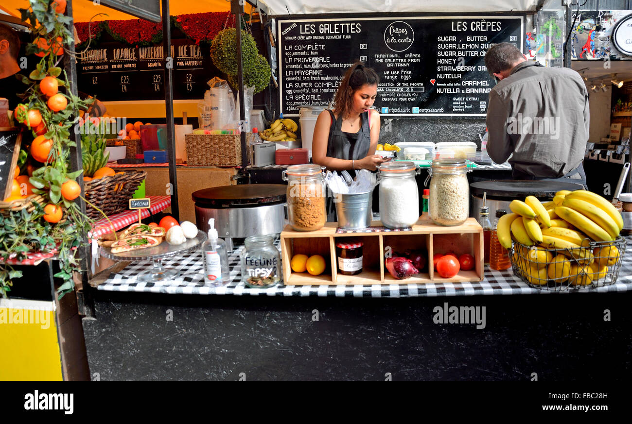 Londres, Angleterre, Royaume-Uni. Marché de Camden - Crepe / gallette (crêpes) - femme sur son téléphone portable Banque D'Images