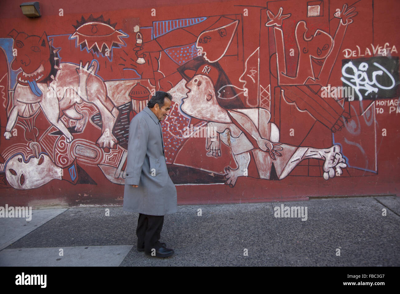 Homme plus âgé promenades au bord de l'une des nombreuses peintures murales en espagnol Harlem, New York City. Banque D'Images
