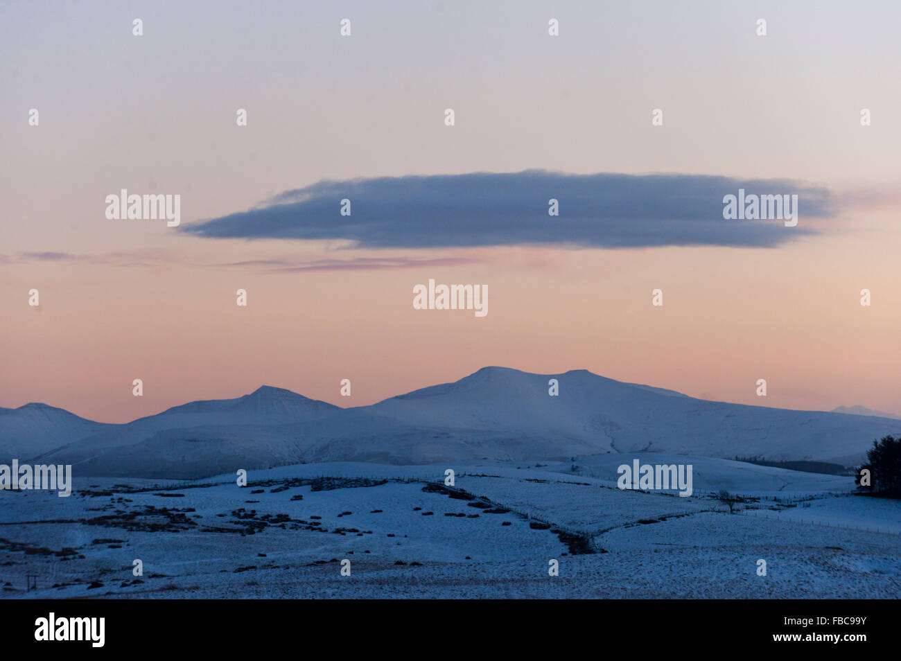 Brecon Beacons, Powys, Wales, UK. 14 janvier, 2016. Un nuage plane sur les cimes enneigées des Brecon Beacons comme la journée se termine. 5cm de neige sont tombés sur des terres en Powys hier soir. Credit : Graham M. Lawrence/Alamy Live News. Banque D'Images