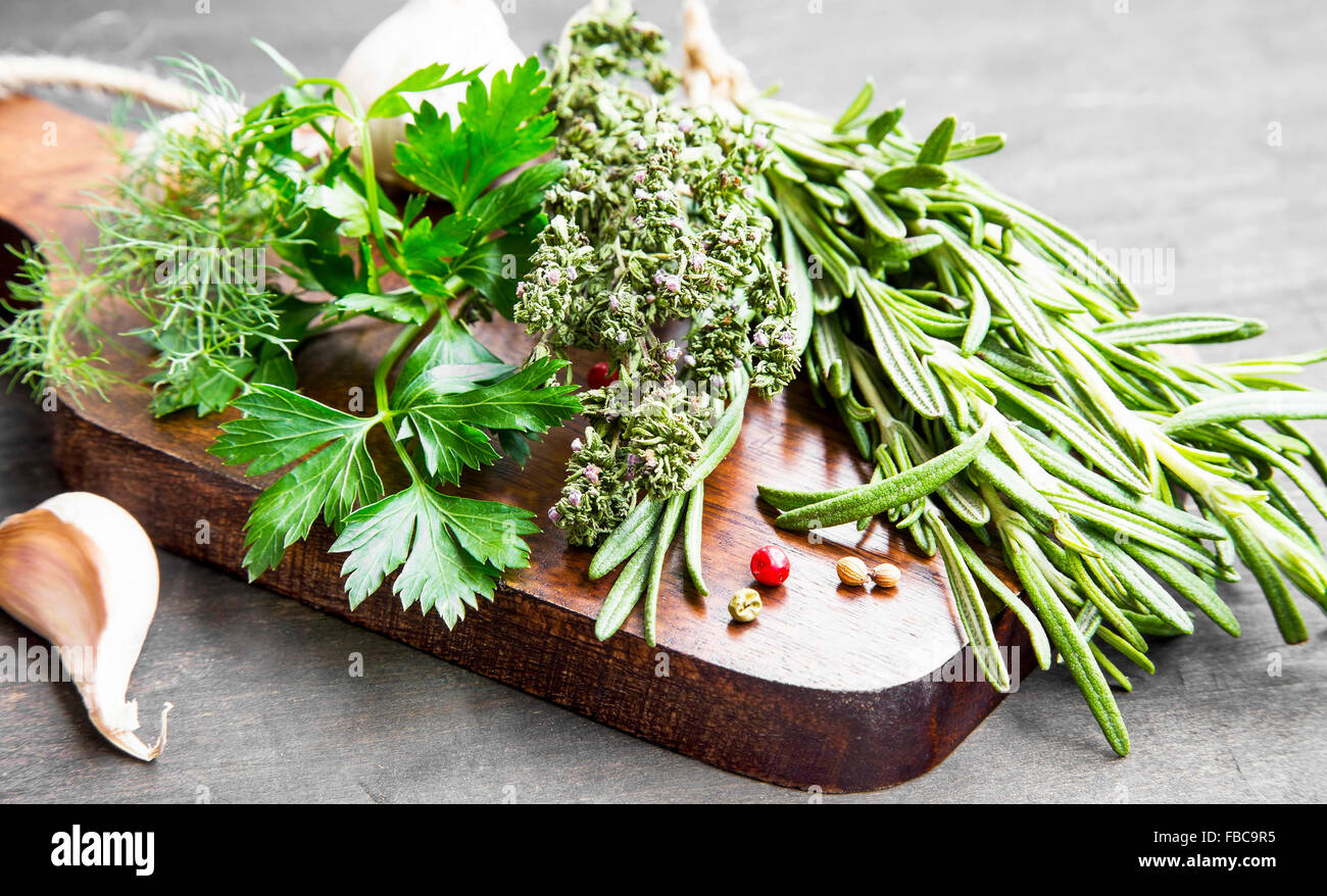 Herbes culinaires de persil, aneth, romarin et thym sur planche de bois Banque D'Images