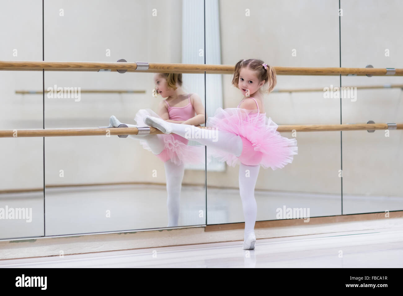 Petite fille ballerine dans un tutu rose. Adorable enfant danse ballet classique dans un livre blanc studio. Les enfants de la danse. Banque D'Images