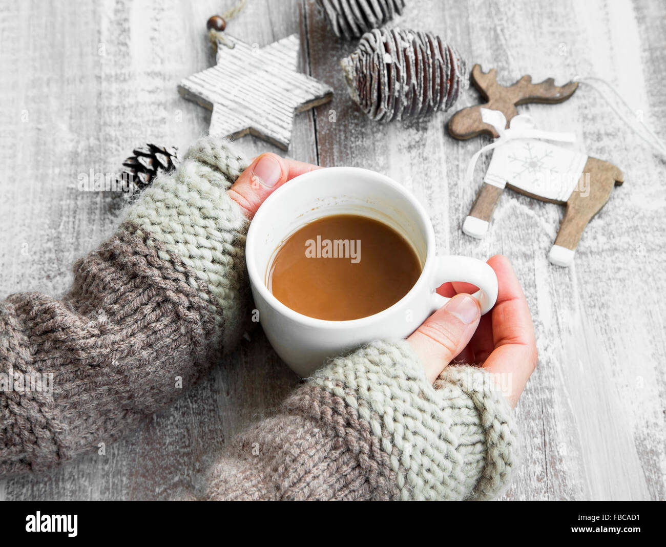 Holding Mug chocolat avec des ornements en bois peint sur Banque D'Images