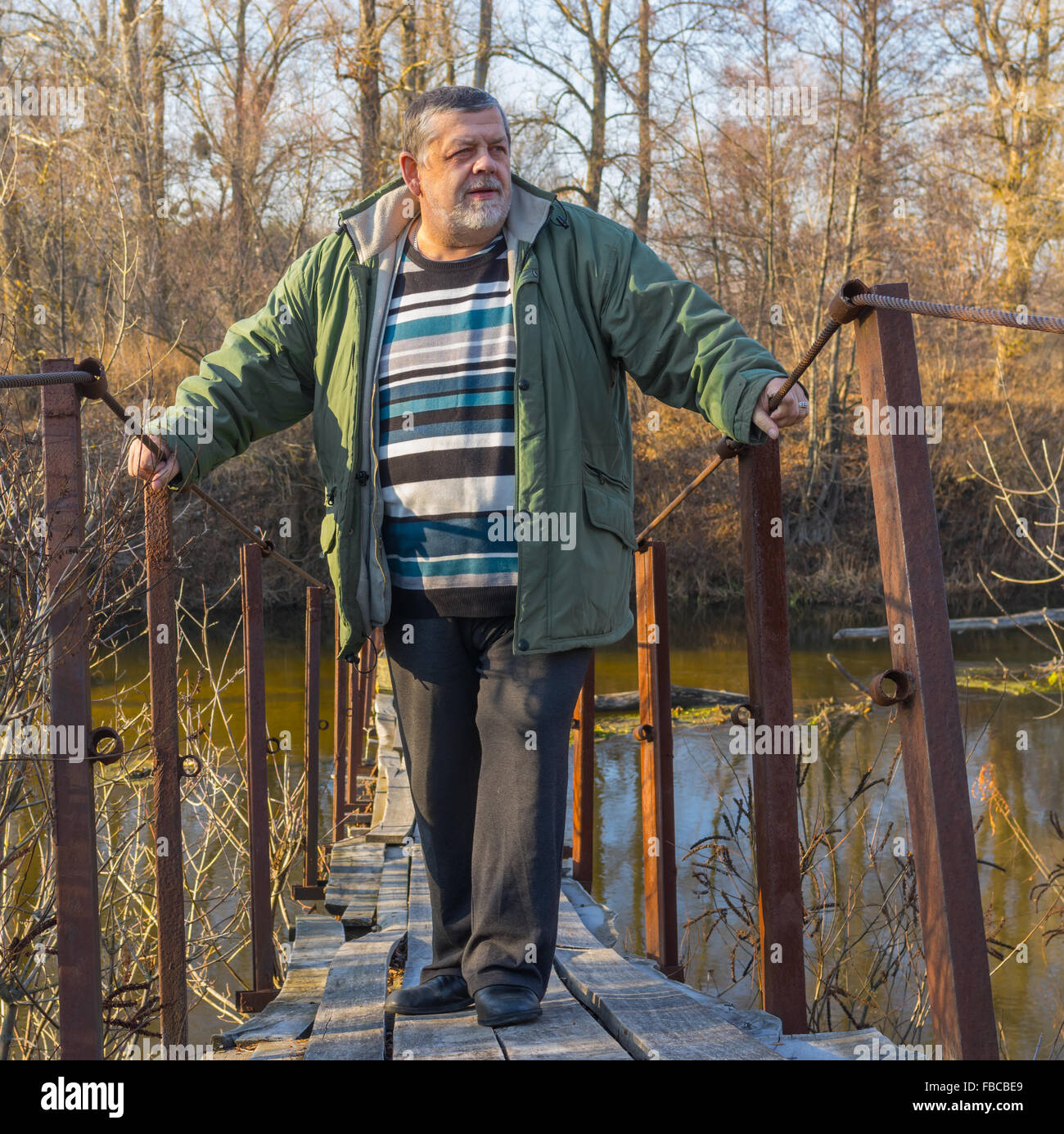Man sur un pont suspendu au-dessus de la rivière Vorskla en Ukraine Banque D'Images