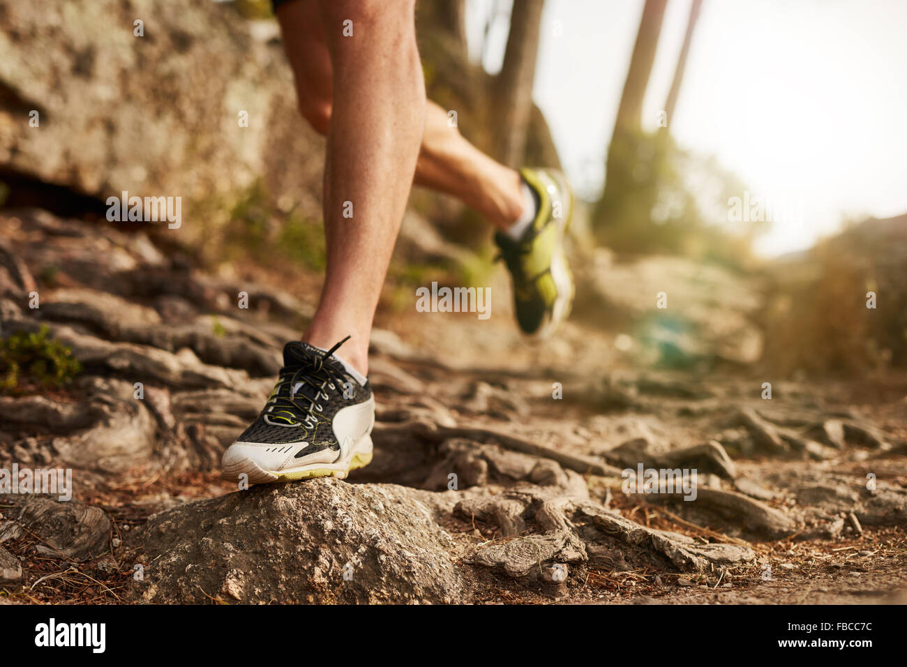 Close-up of trail chaussure de course sur des terrains rocheux. Les jambes du coureur masculin travaillant sur terrain extrême à l'extérieur. Banque D'Images