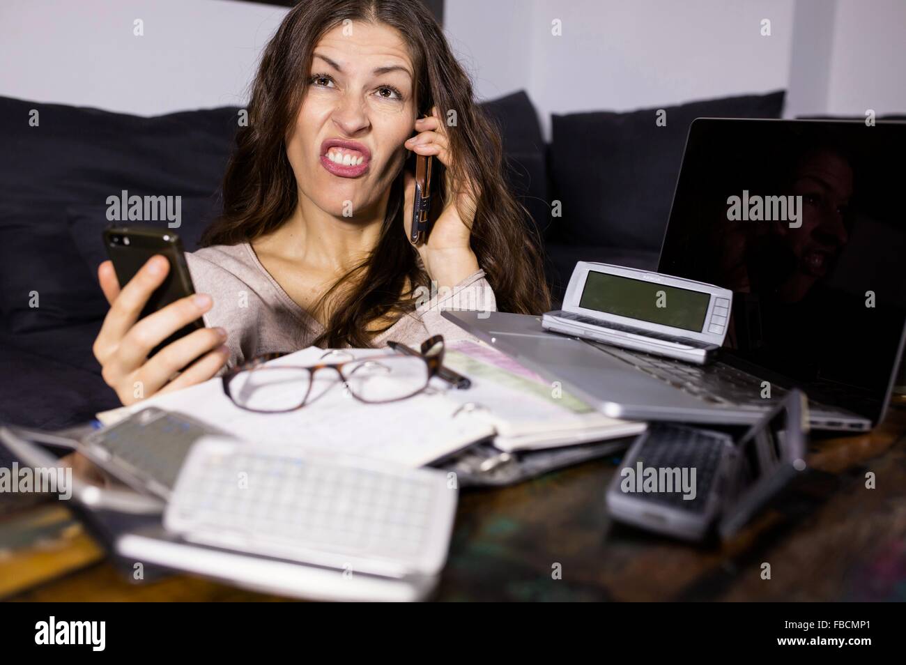 Business Woman phoning entouré par la technologie des télécommunications, de l'ordinateur portable mobile iphone câble Banque D'Images