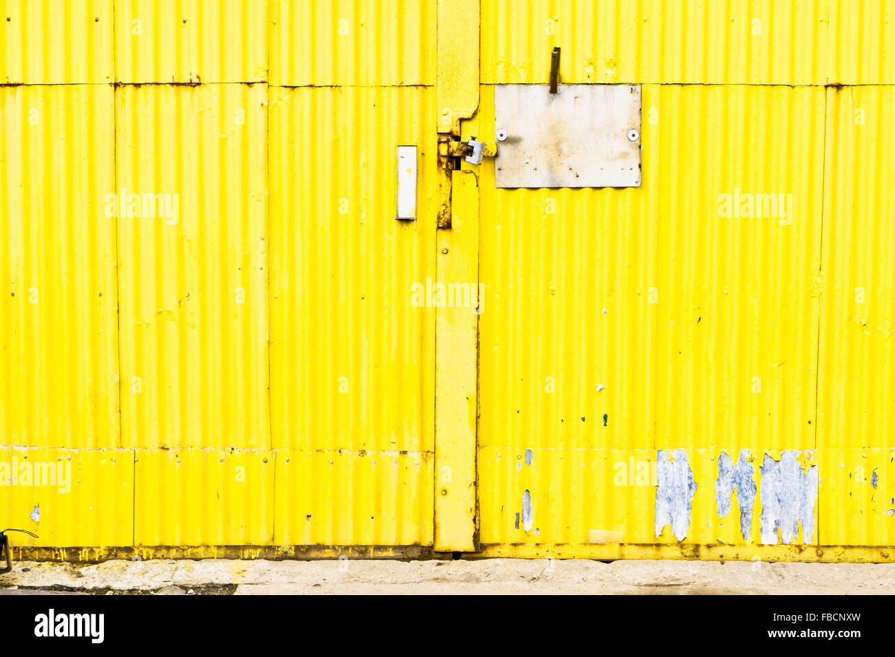 Partie d'une porte de métal ondulé jaune Banque D'Images