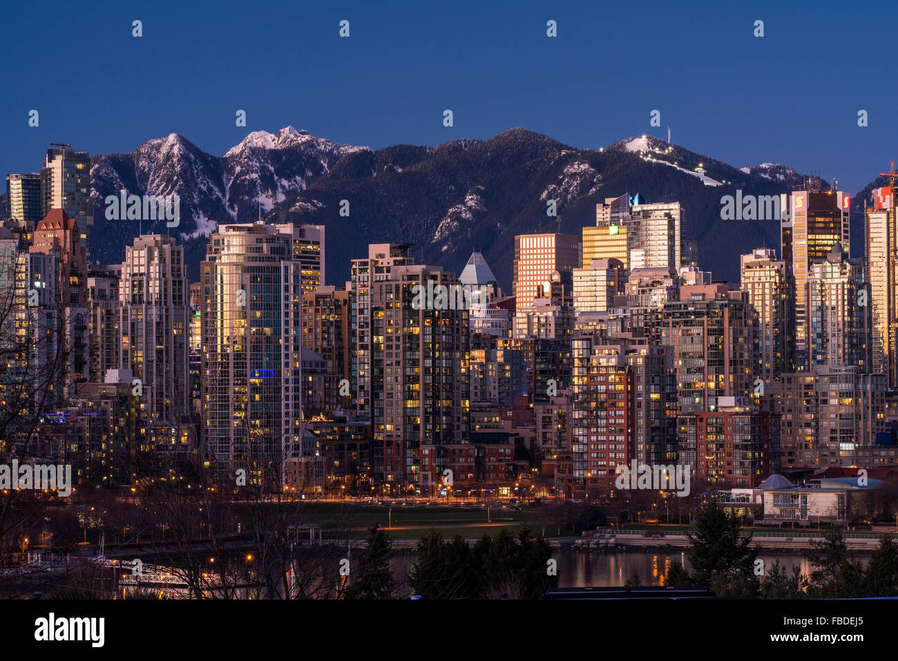 Le centre-ville avec les montagnes enneigées derrière au crépuscule, Vancouver, British Columbia, Canada Banque D'Images