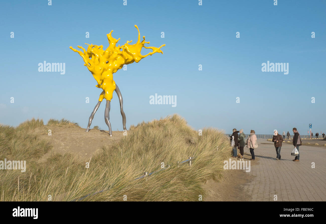 Westende, Belgique. 31 Dec, 2015. Les visiteurs passent devant l'œuvre 'Olnetop" par l'artiste Nick Ervinck, brillant dans les couleurs jaune vif sur le front de mer à Middelkerke, Belgique, 31 décembre 2015. Les huit mètres de hauteur, qui rappelle la sculpture d'éclaboussures vagues qui un rivage, fait partie de la sculpture park permanent sur la côte et a été conçue au cours de l'art project04 Beaufort en 2012. Photo : Lukas Schulze/DPA - PAS DE FIL - SERVICE/dpa/Alamy Live News Banque D'Images