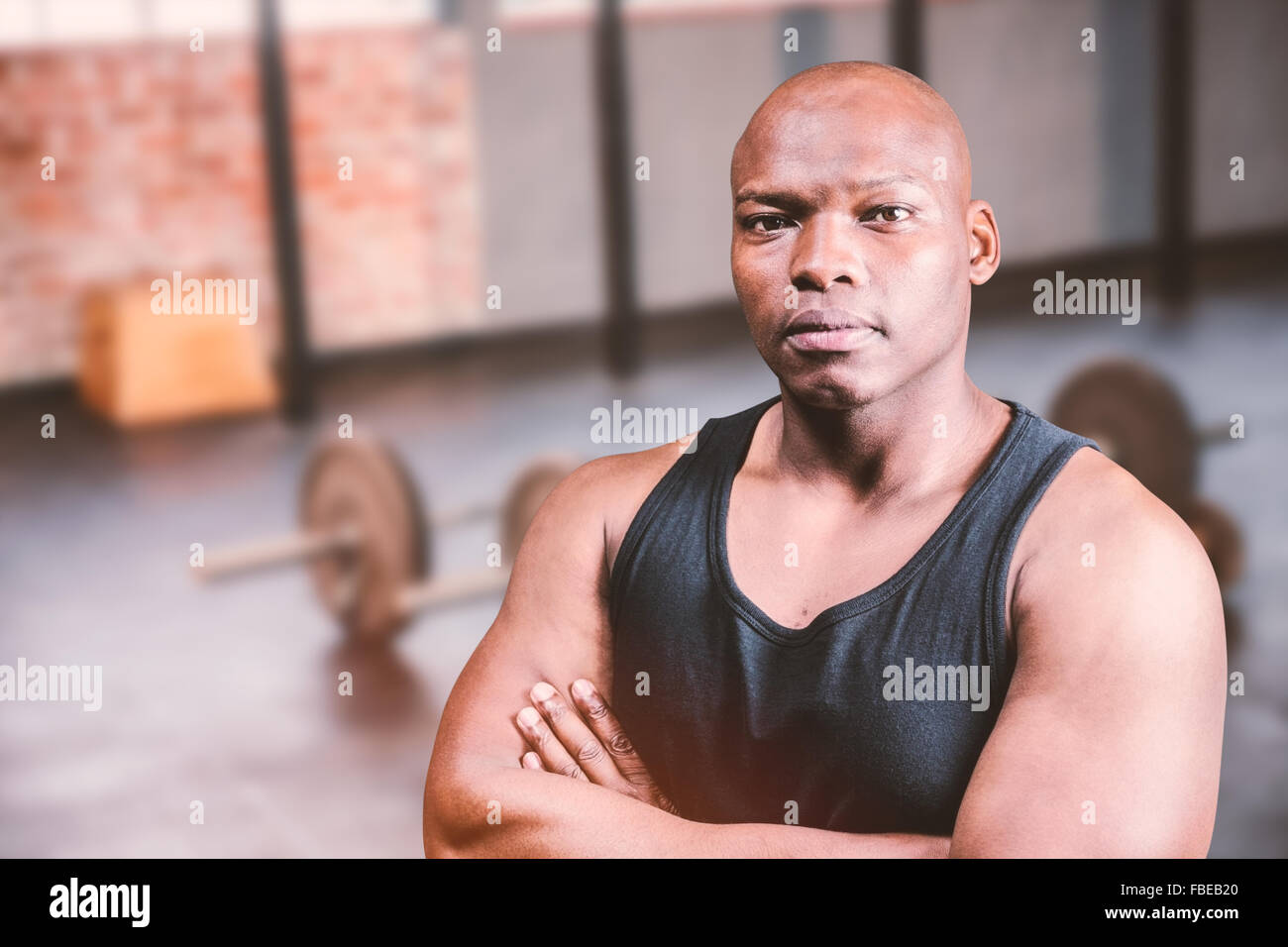 Composite image of bodybuilder chauve avec les bras croisés Banque D'Images