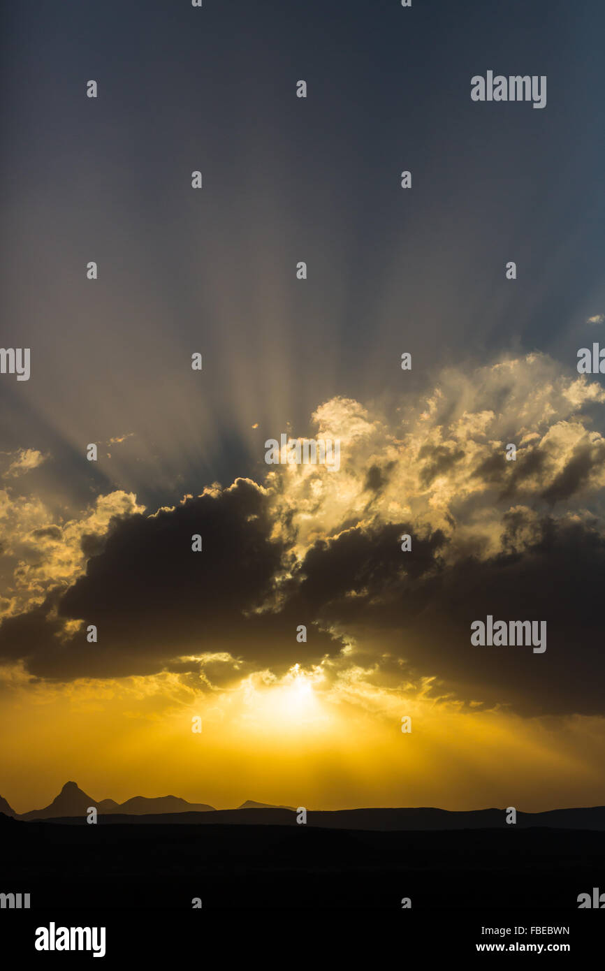 Le paramètre du soleil percer les nuages au-dessus du désert dans le parc national Big Bend, États-Unis Banque D'Images