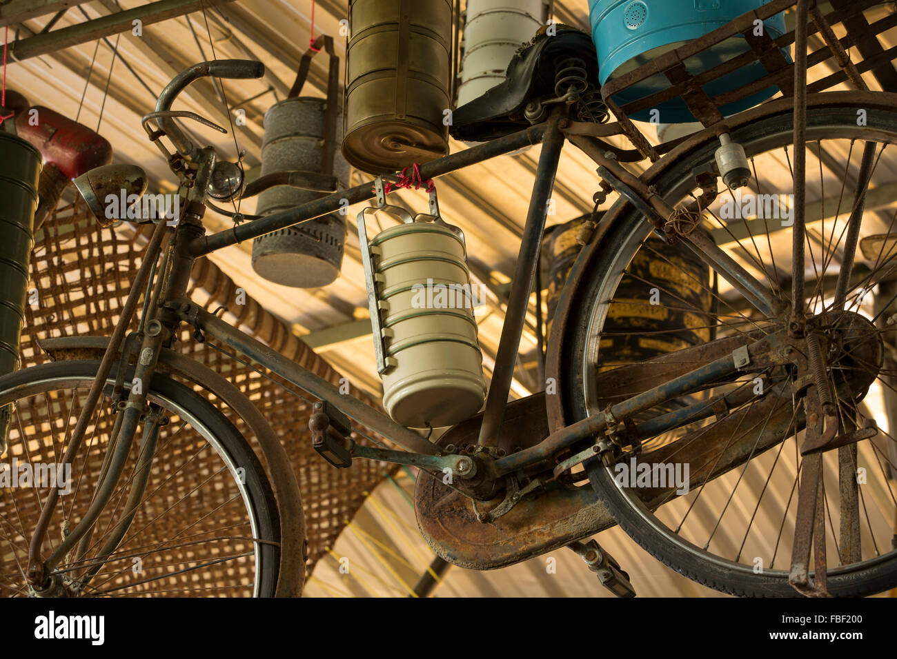Meubles anciens et divers contenants tiffin vélo suspendu à un plafond, dans l'arrière-salle d'un restaurant à Georgetown Penang. Banque D'Images