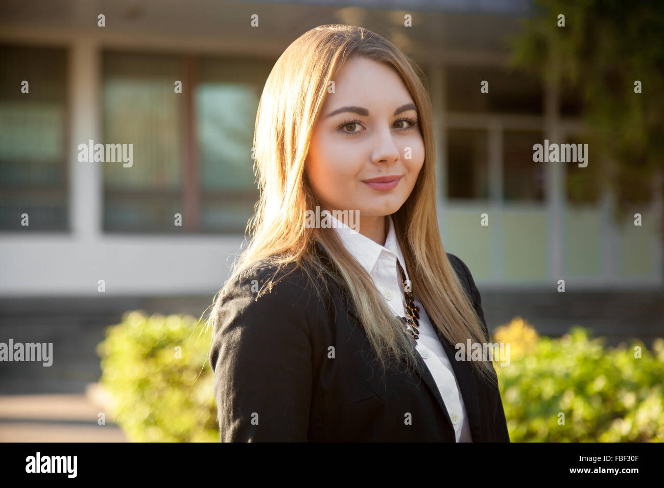 Portrait of young smiling woman habillé de l'usure, costume noir et chemise blanche sur sunny street Banque D'Images