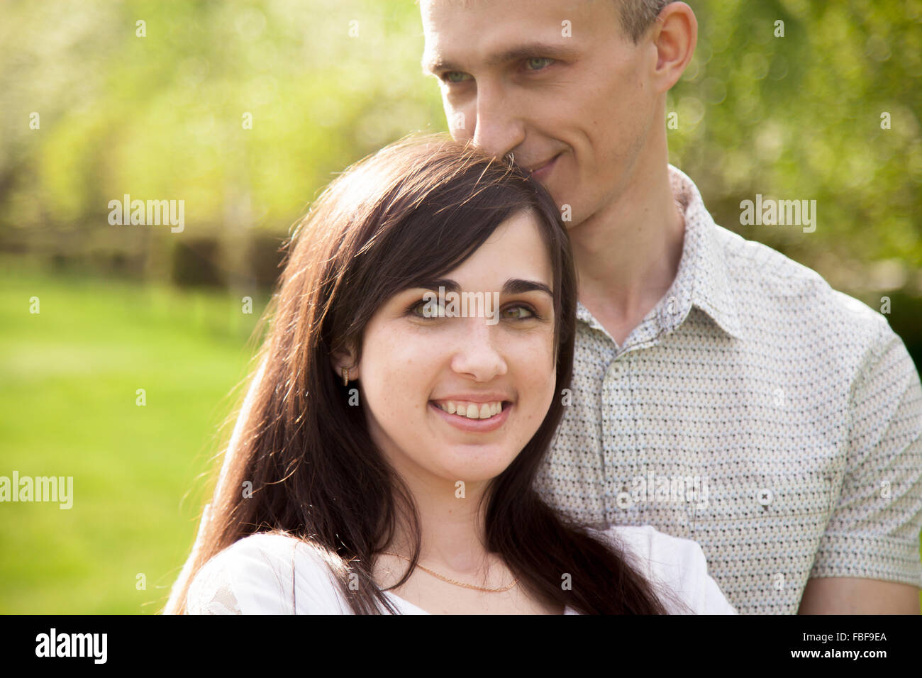 Couple d'amoureux sur une date, jeune homme serrant tendrement son happy smiling girlfriend Banque D'Images
