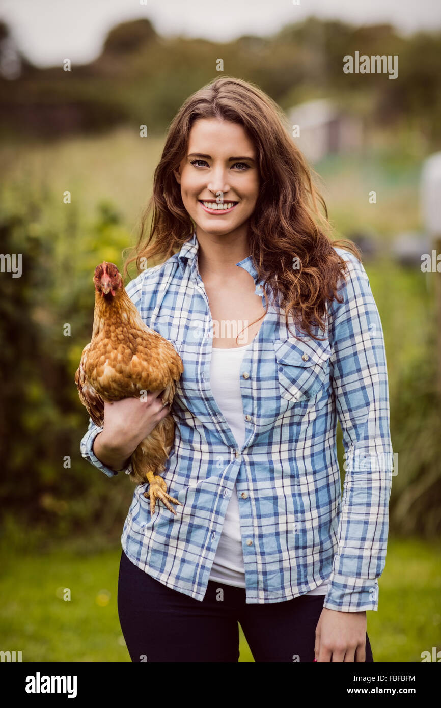 Smiling woman holding chicken Banque D'Images