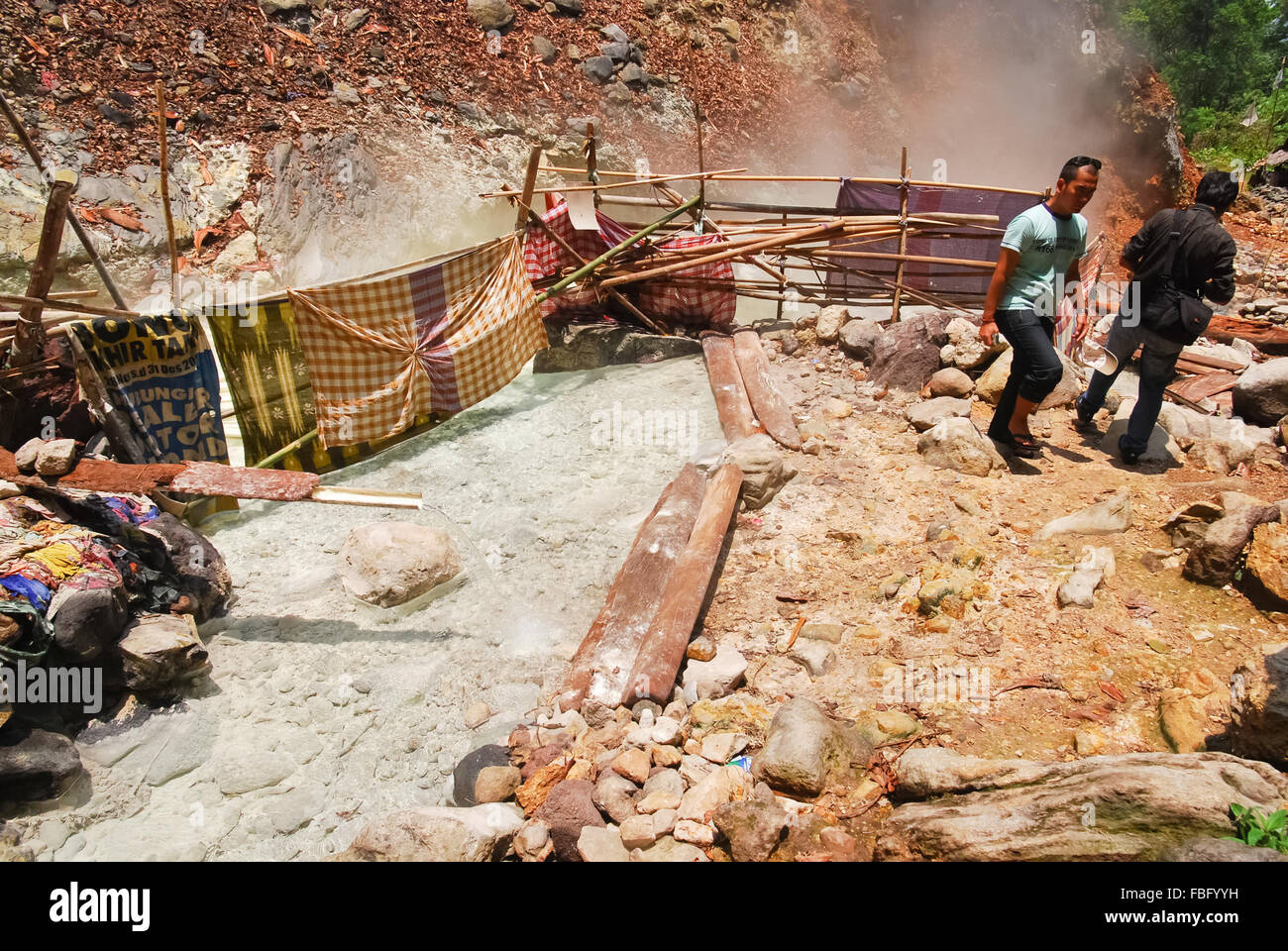 Visiteurs se tenant sur le côté d'une source chaude au pied du volcan du Mont Rajabasa en chemin Belerang, Kalianda, South Lampung, Lampung, Indonésie. Banque D'Images