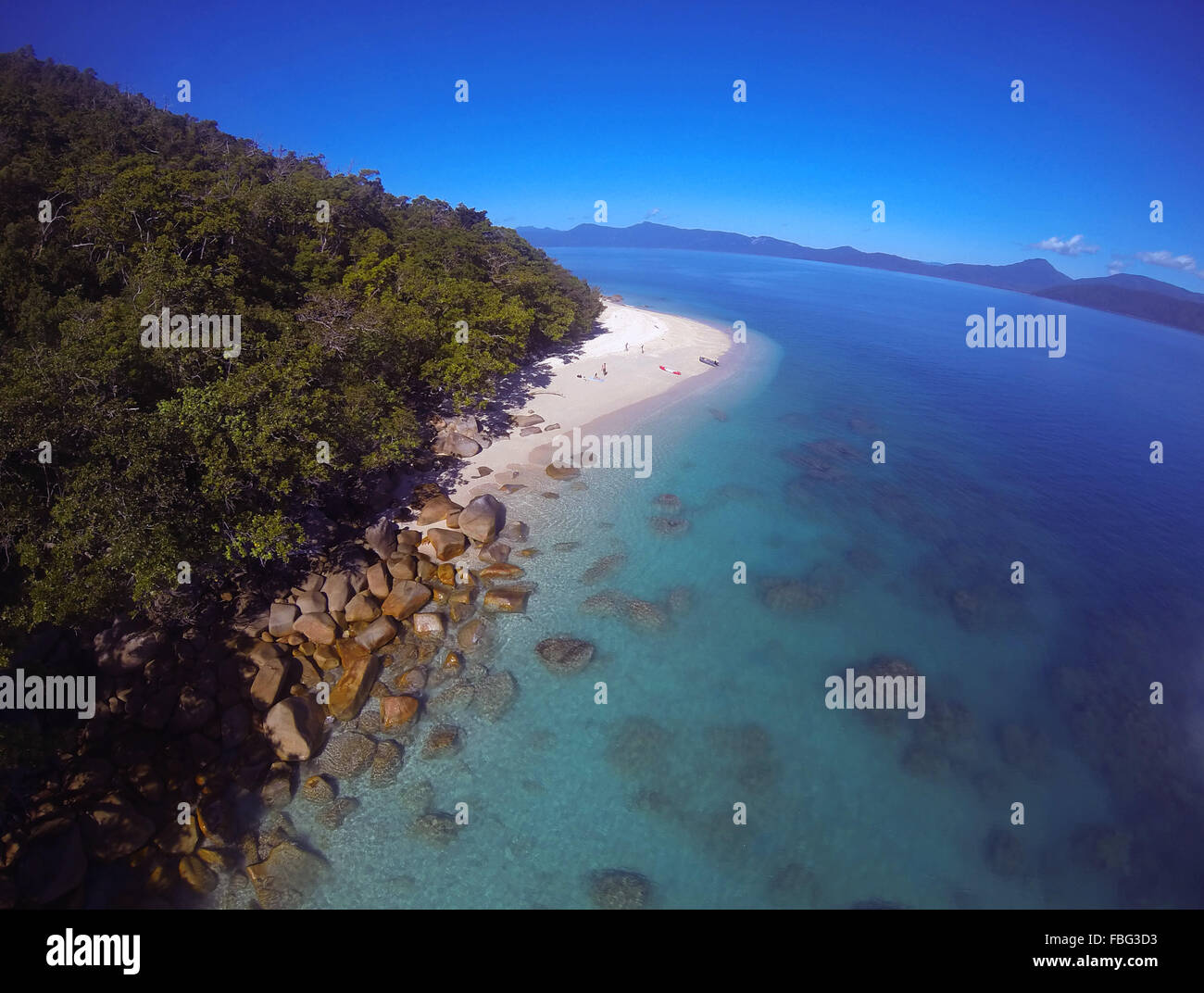 Plage et des récifs de l'île de Fitzroy, sur la Grande Barrière de Corail, avec la côte nord du Queensland en Australie, l'arrière-plan Banque D'Images