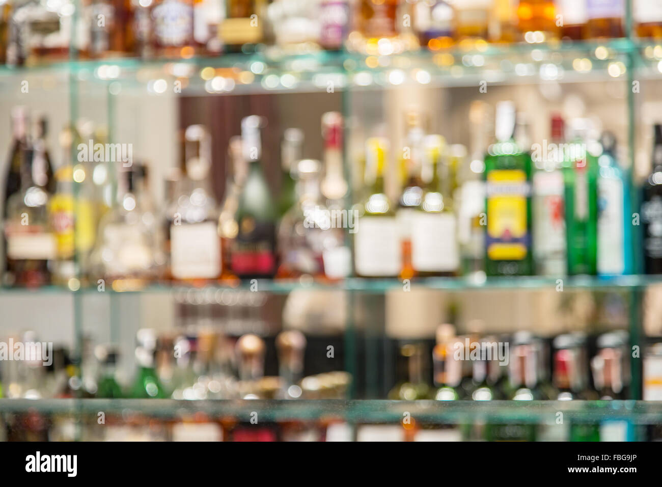 Comptoir de bar en verre avec étagères avec des bouteilles d'alcool trouble  sur l'arrière-plan Photo Stock - Alamy
