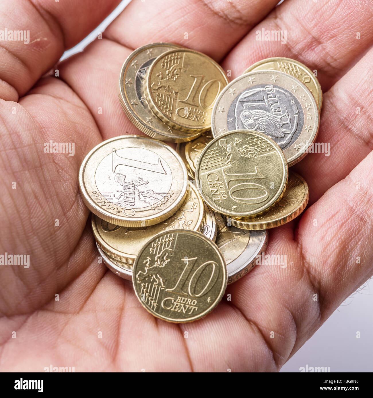 Pièces en euro sur le palm d'homme sur fond blanc. Banque D'Images