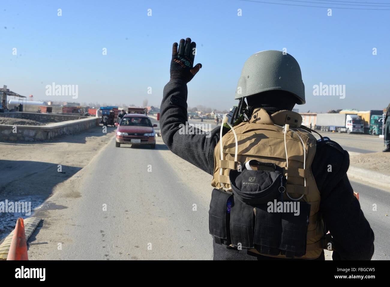 Ghazni, en Afghanistan. 16 janvier, 2016. Un policier afghan arrêtant la voiture à un poste de contrôle de la police dans la province de Ghazni, Afghanistan, le 16 janvier 2016. Environ 37 militants talibans ont été tués comme des heurts ont éclaté dans la province méridionale de Helmand, un fonctionnaire a déclaré samedi. Credit : Sayed Mominzadah/Xinhua/Alamy Live News Banque D'Images
