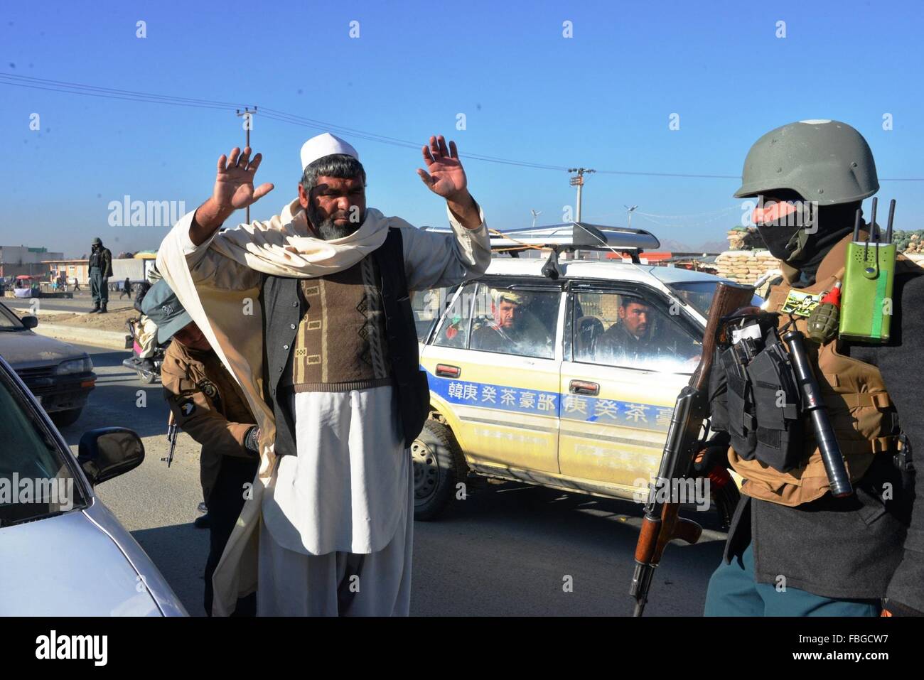 Ghazni, en Afghanistan. 16 janvier, 2016. Un policier afghan cherche un passager à un poste de contrôle de la police dans la province de Ghazni, Afghanistan, le 16 janvier 2016. Environ 37 militants talibans ont été tués comme des heurts ont éclaté dans la province méridionale de Helmand, un fonctionnaire a déclaré samedi. Credit : Sayed Mominzadah/Xinhua/Alamy Live News Banque D'Images