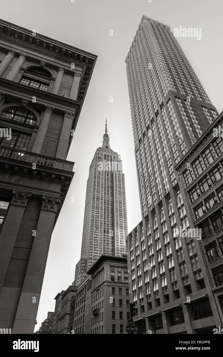 Noir & Blanc, low angle view du style Art Déco Empire State Building gratte-ciel à partir de la 5ème Avenue, New York City Banque D'Images