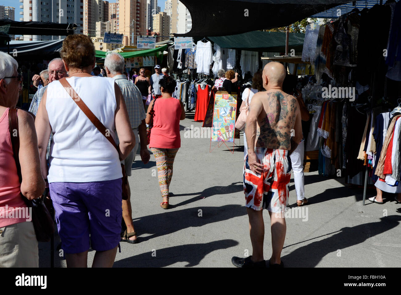 Touriste britannique Baring son haut du corps tatoués en short décoré avec l'Union Jack sur un marché hebdomadaire à Benidorm, Alicante, Banque D'Images