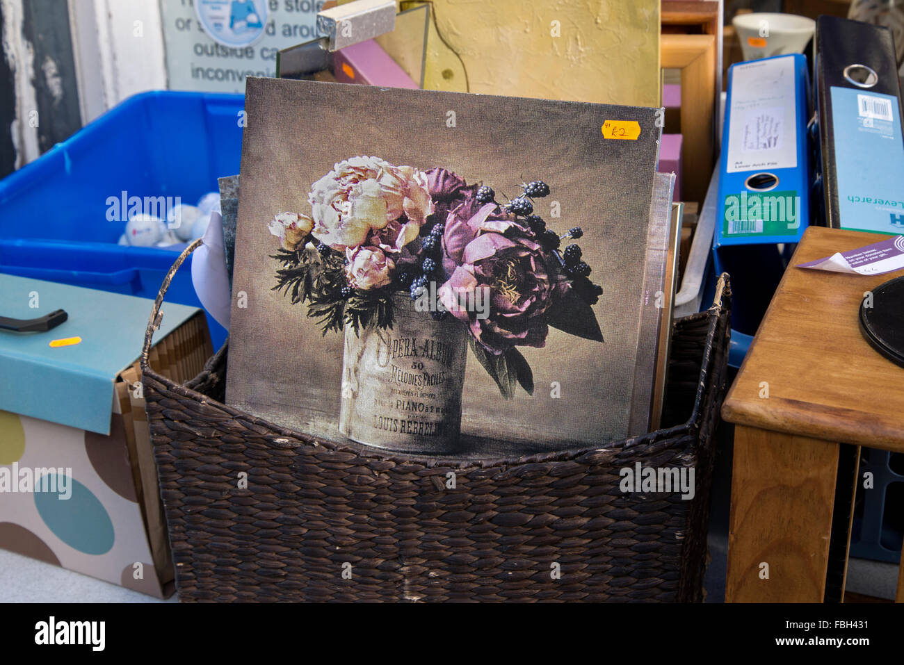 Un panier contenant une peinture d'un bouquet de fleurs à l'extérieur d'un magasin de charité dans Causewayside, Édimbourg, Écosse, Royaume-Uni. Banque D'Images