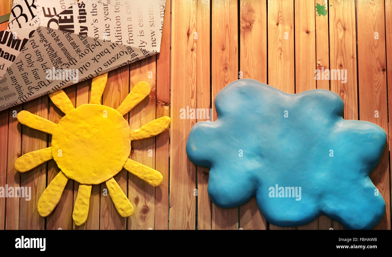 Beau Soleil jaune et un nuage bleu sur un mur en bois Banque D'Images