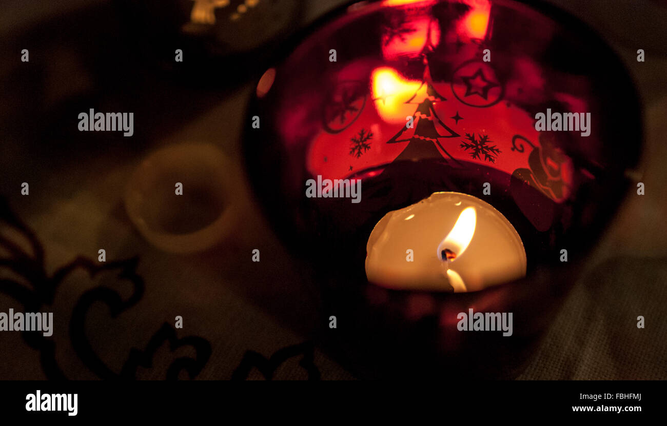 Tealight candle in a red Christmas cup, lumière tamisée. Banque D'Images