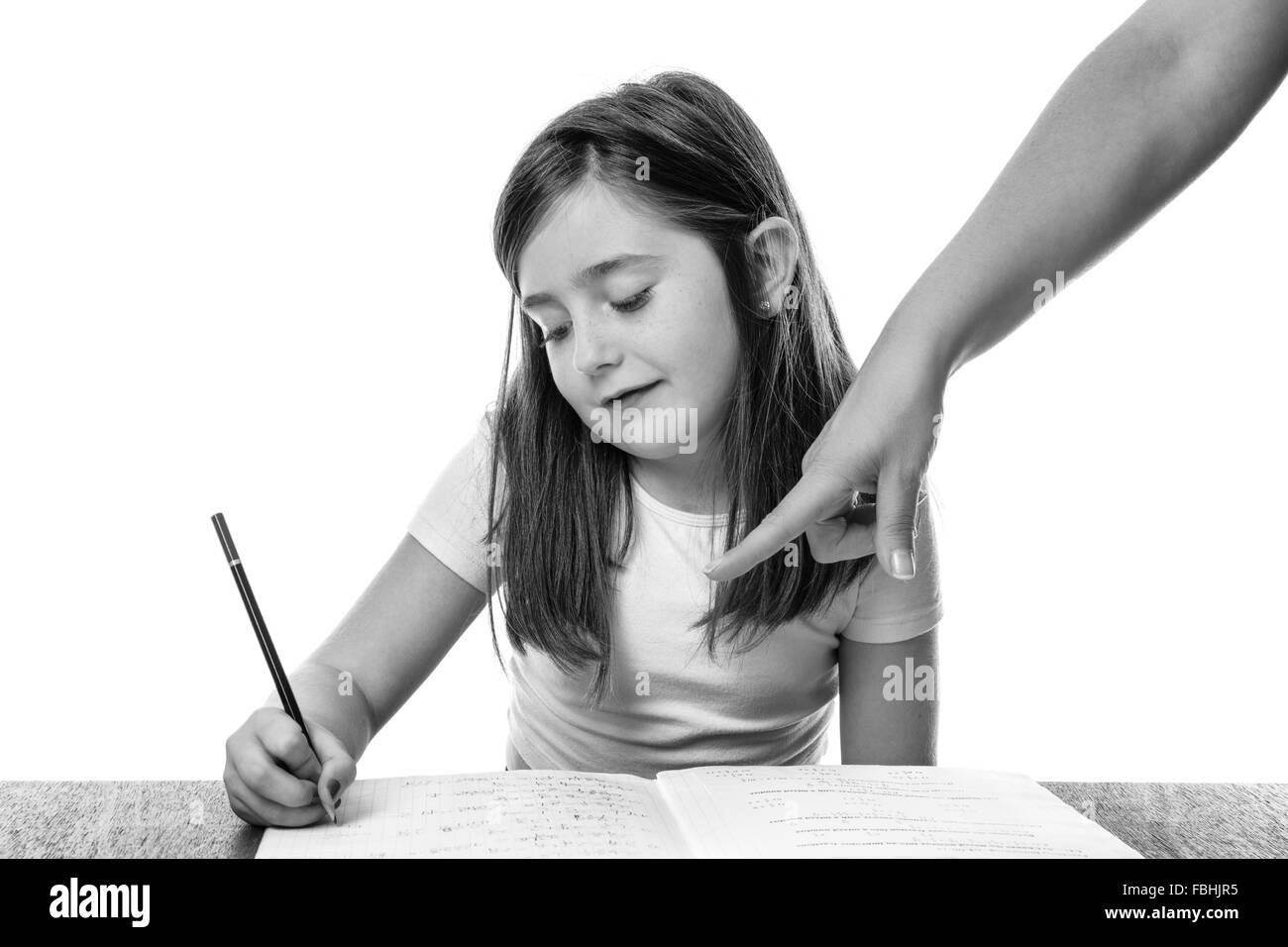 Jeune fille dans un livre écrit avec sa mère pointer du doigt son travail Banque D'Images