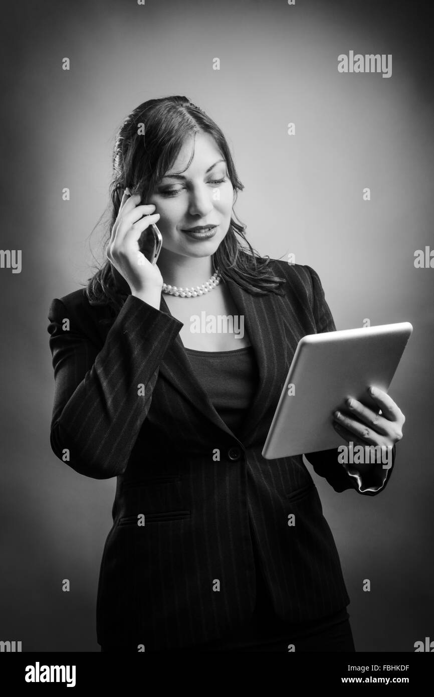 Business Woman est le multitâche, en utilisant son ordinateur tablette et téléphone mobile Banque D'Images