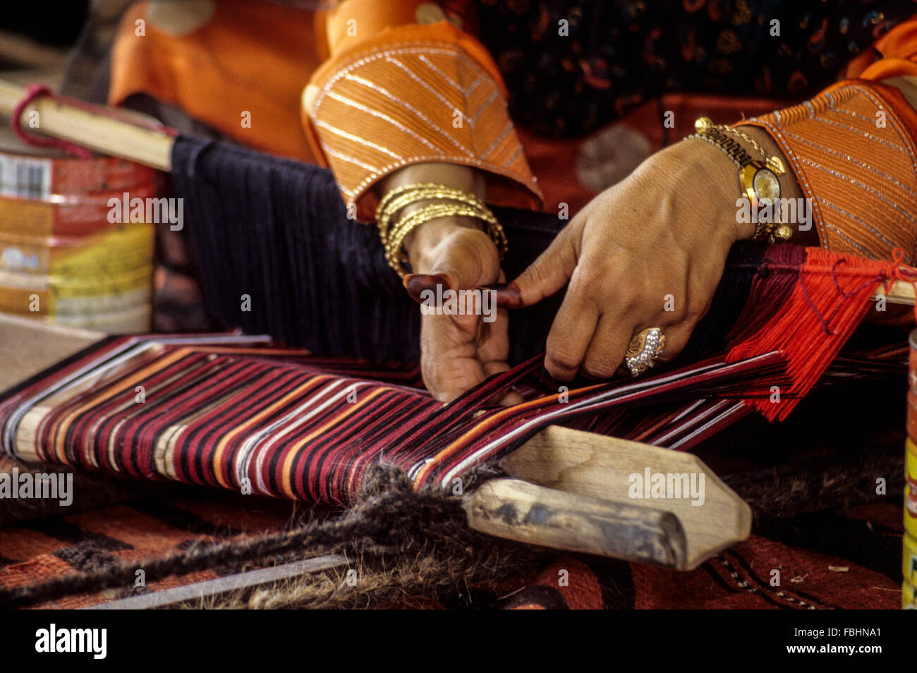 L'Oman. Woman's Hands tissage d'une courroie. Banque D'Images