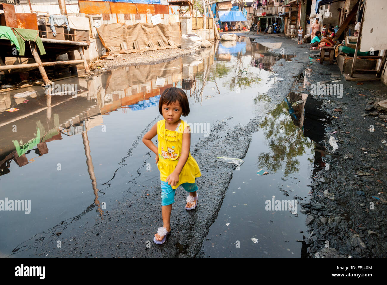 Un enfant qui marche dans une rue où l'eau est engorée juste après une inondation à Muara Baru, dans la zone côtière de Jakarta, en Indonésie. Banque D'Images