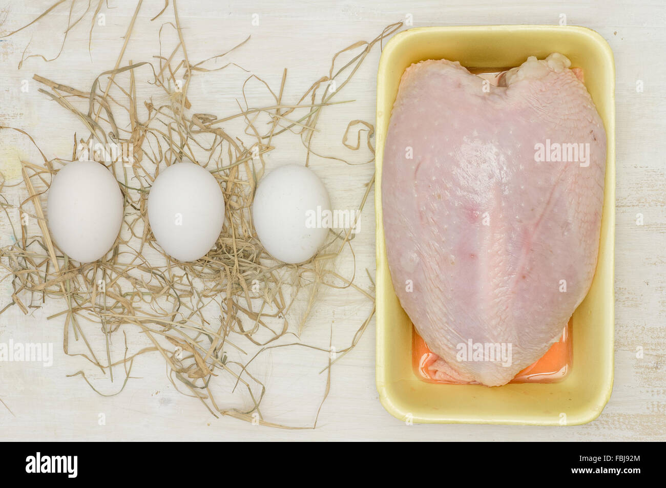 Poitrine de poulet et trois oeufs sur la paille Vue de dessus Banque D'Images