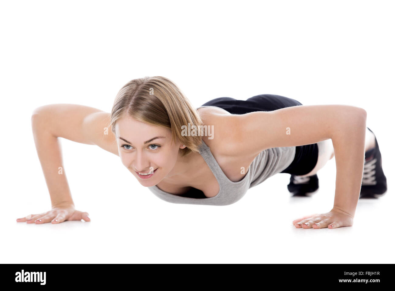 Portrait de jeune femme belle slim faisant des exercices de remise en forme sur le tapis, le préchauffage, push-ups, pleine longueur de l'image studio isolé Banque D'Images
