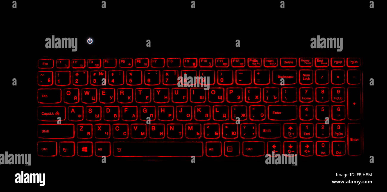 Rétroéclairage du clavier d'ordinateur portable. Voyant rouge allumé et l'ordinateur. Fond sombre Banque D'Images