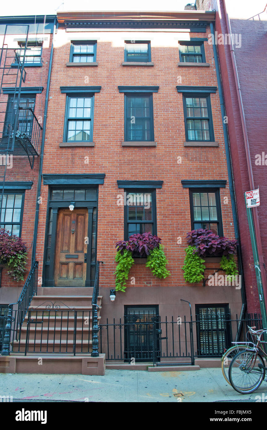 New York, États-Unis d'Amérique : Skyline, maison rouge à Greenwich Village, fleurs et un vélo Banque D'Images