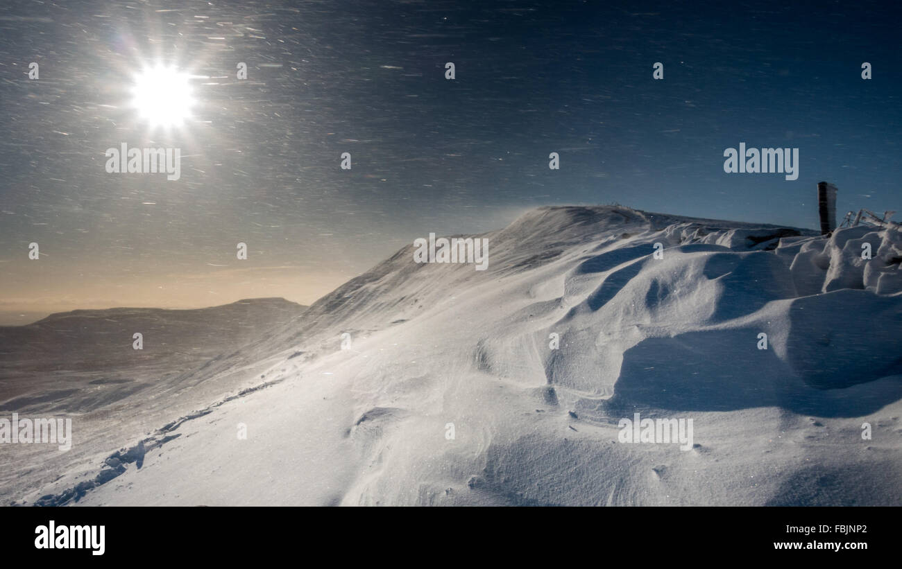 Spindrift soufflant sauvagement sur un jour d'hiver ensoleillé sur la crête du sommet de Whernside, Yorkshire, UK Banque D'Images