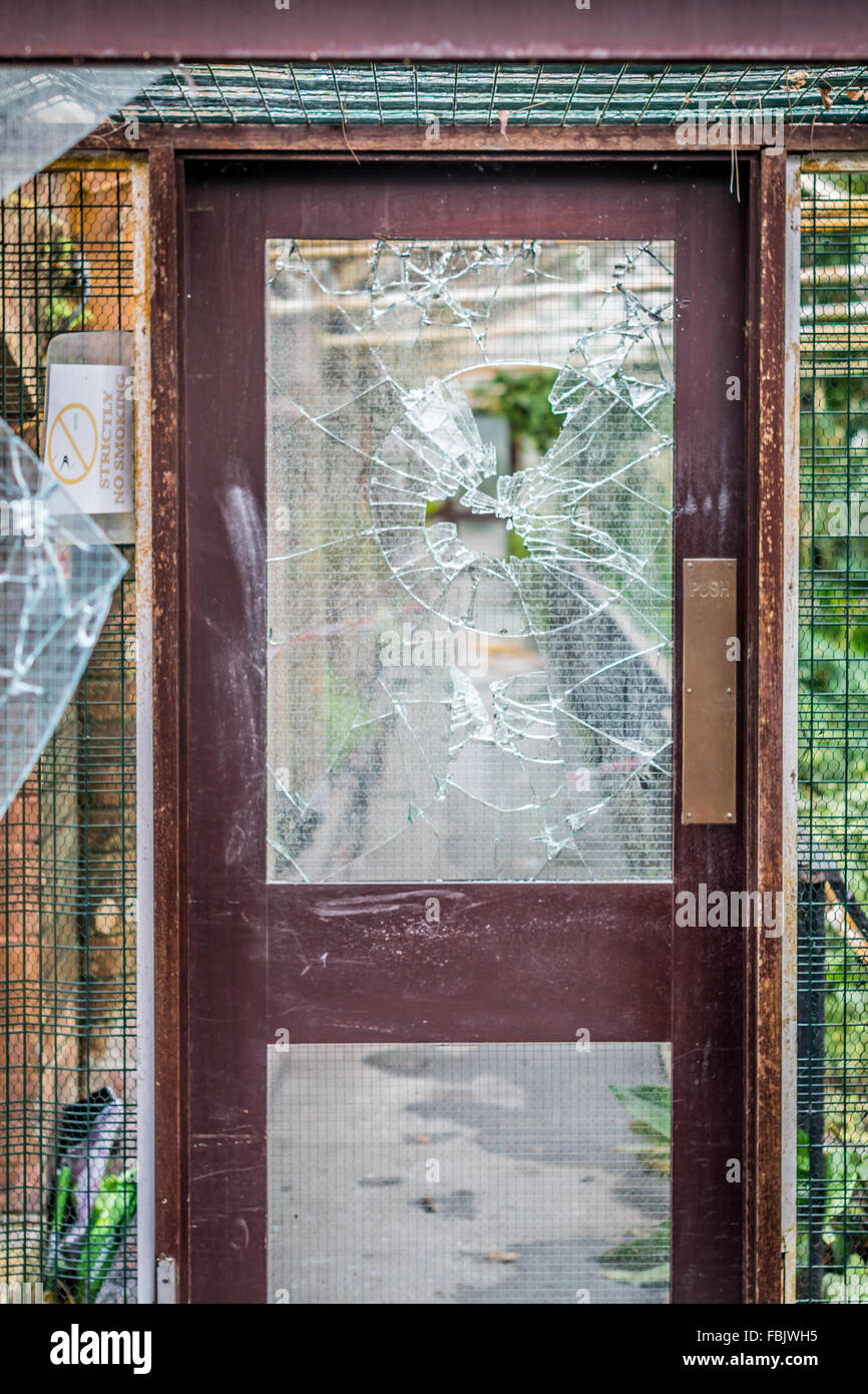 A brisé la vitre d'une porte en bois. Banque D'Images