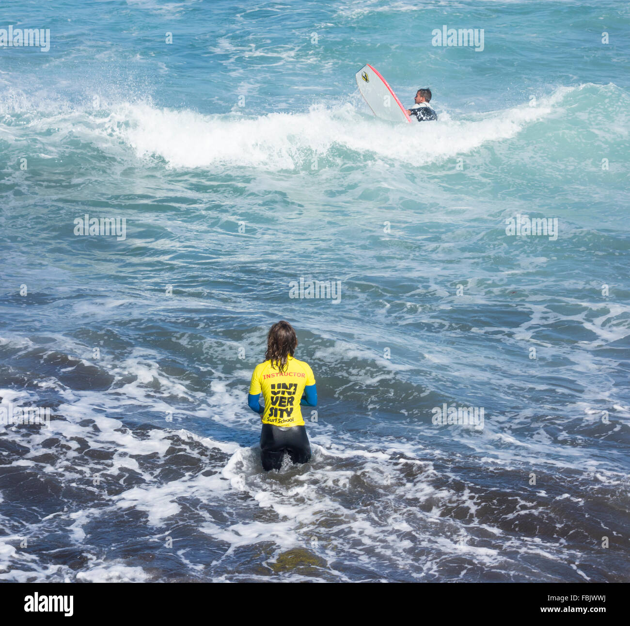 Instructeur de surf féminin en permanent donnant la mer leçon Banque D'Images