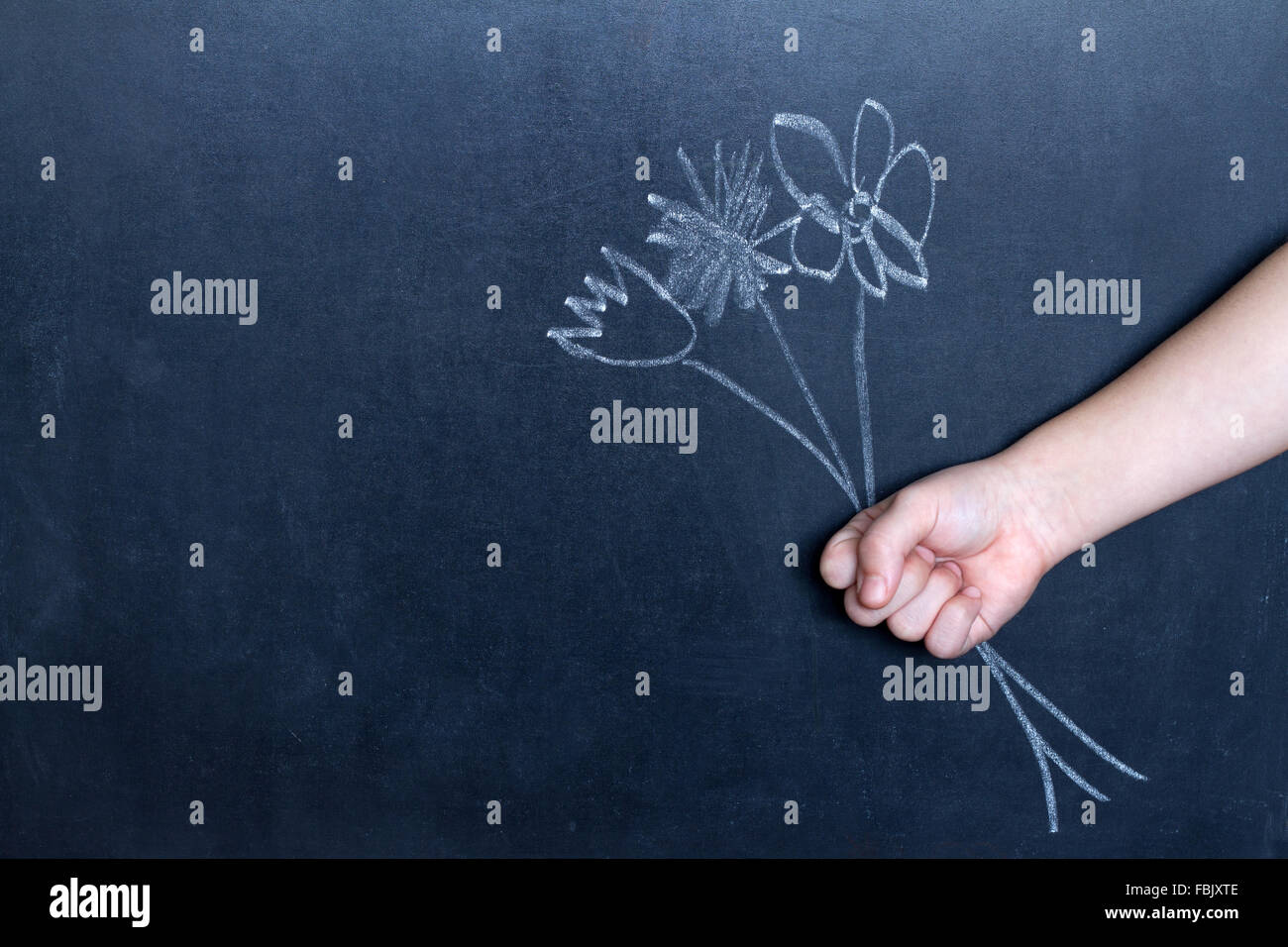 La main de fleurs et de l'enfant résumé fond concept sur tableau noir Banque D'Images
